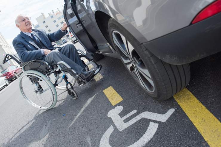 Anziano disabile sale sull'auto - Fonte AdobeStock