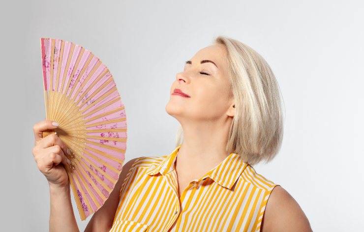 Donna in menopausa con ventaglio - Fonte AdobeStock